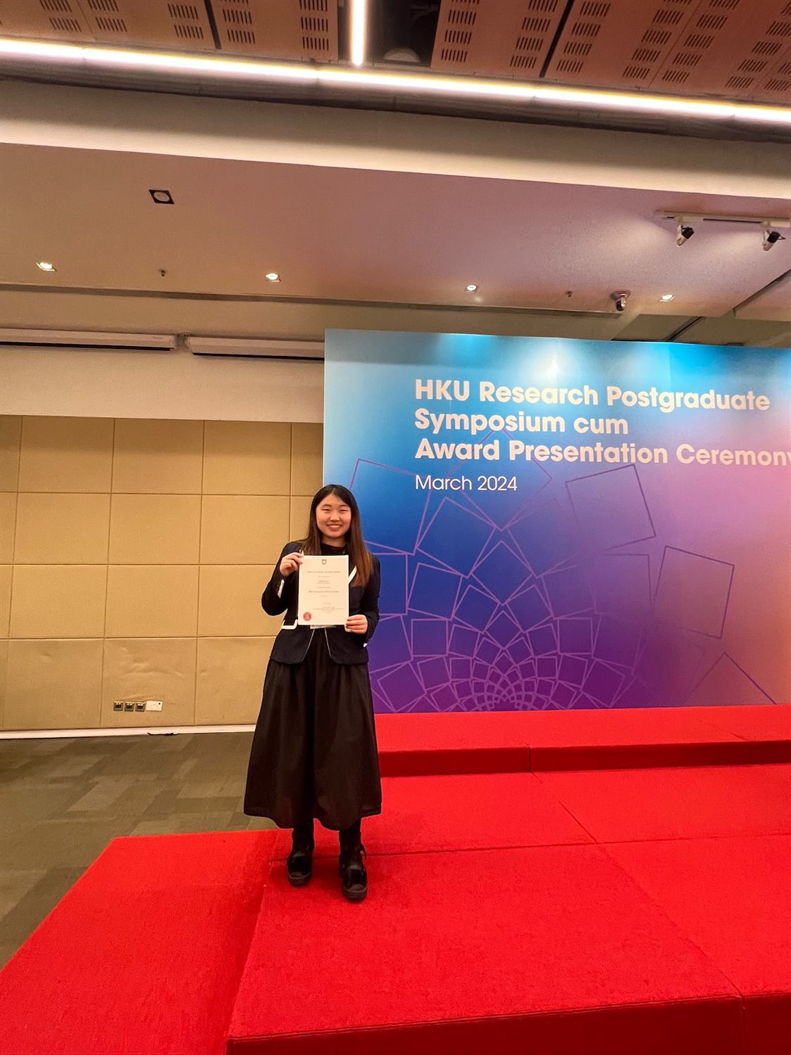 Zhixuan Li holding an award certificate at the HKU Research Postgraduate Symposium cum Award Presentation Ceremony, March 2024